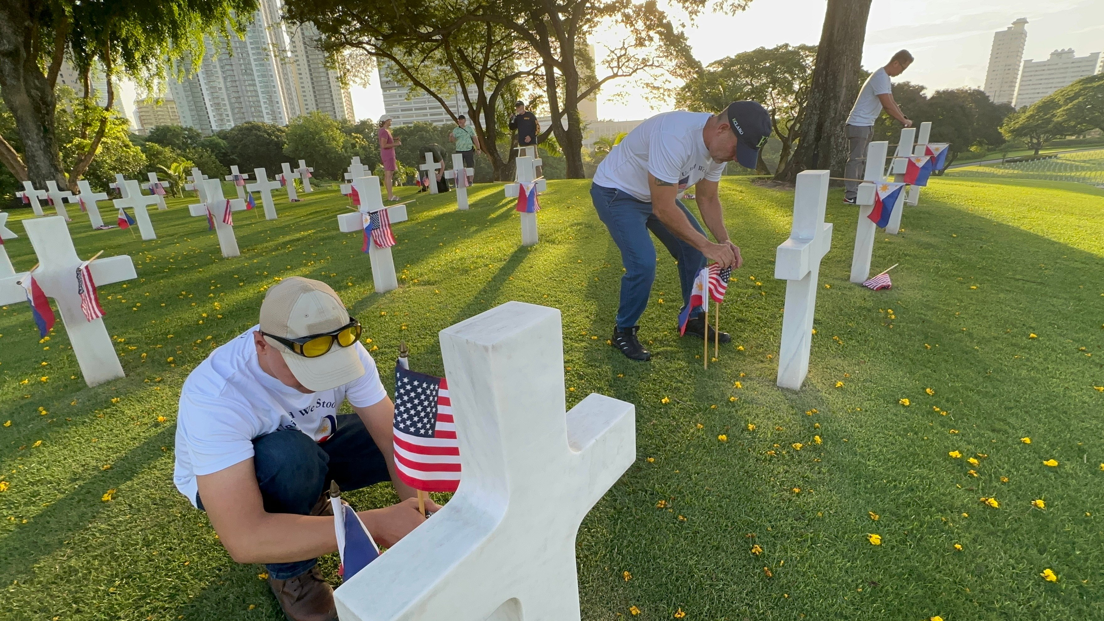 ECLARO team members planting U.S. and Filipino flags at the Manila American Cemetery for Memorial Day 2025