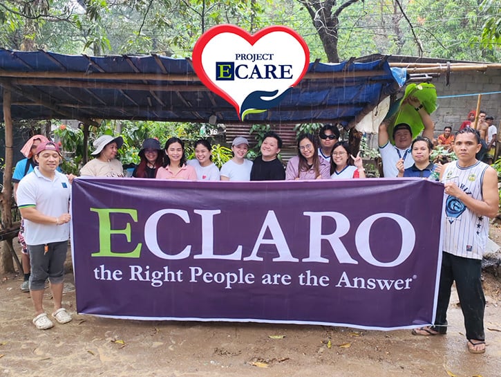 Project E-Care volunteers in the outdoors holding a banner reading ECLARO the Right People are the Answer
