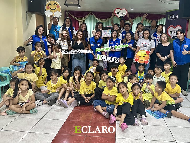 ECLARO volunteers in blue shirts and kids in yellow shirts in classroom 